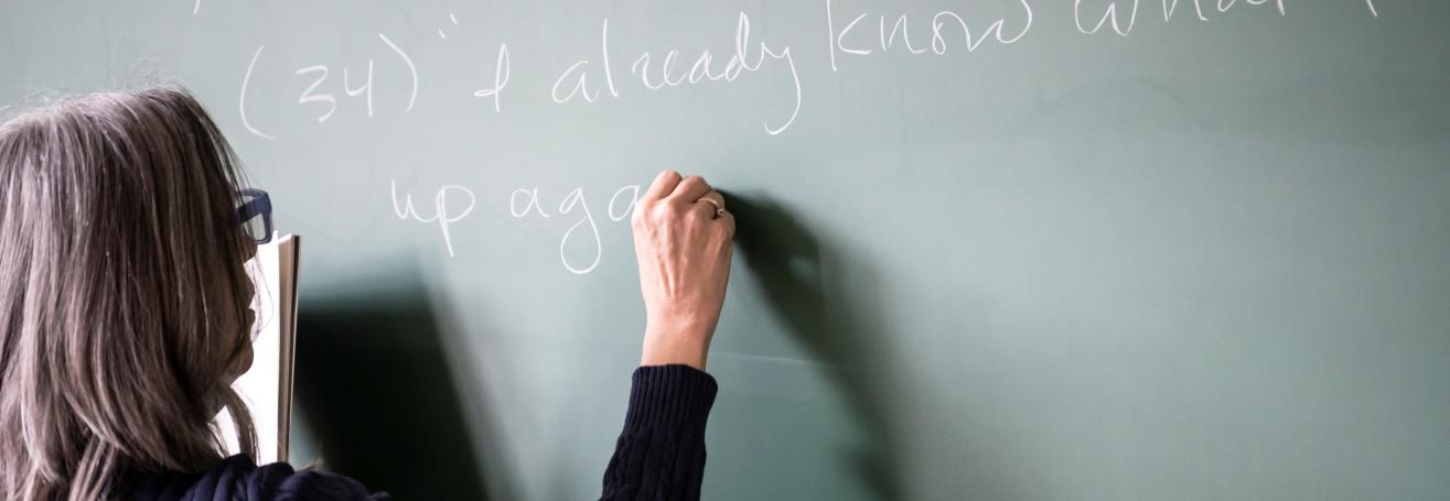 English professor writing on a chalkboard